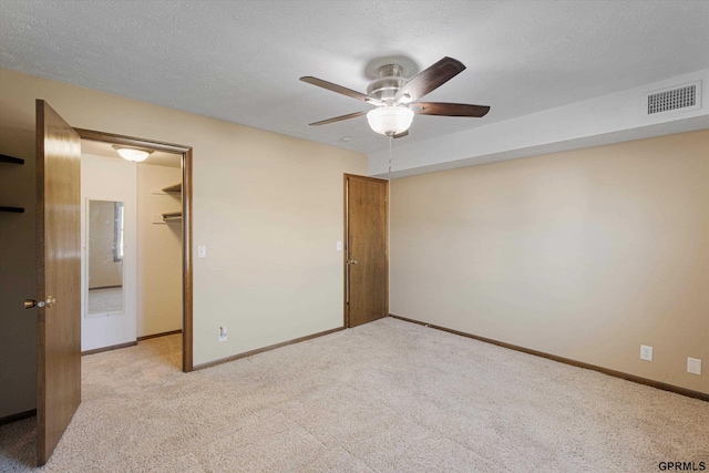 12749 Woodcrest Plz Unit 211B, Omaha, NE 68137 - unfurnished bedroom featuring carpet, baseboards, a walk in closet, a closet, and ceiling fan