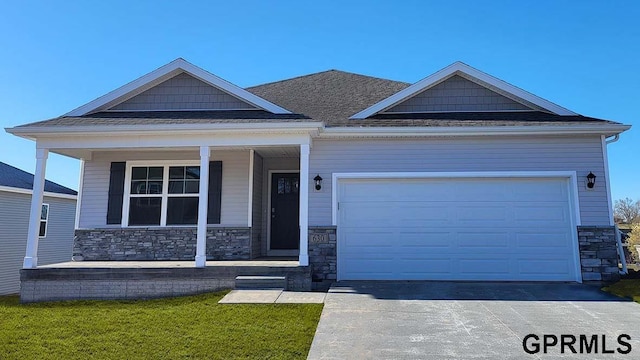 8504 S 179th St, Gretna, NE 68136 - view of front of house with stone siding, a porch, driveway, and an attached garage
