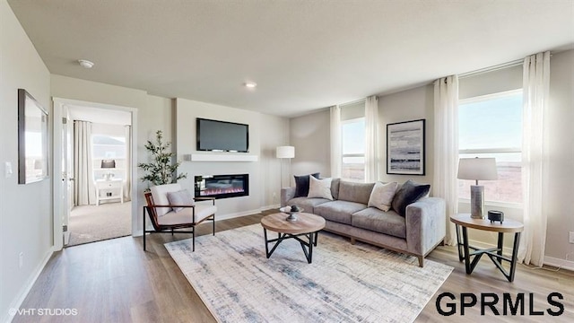 8512 S 179th St, Omaha, NE 68137 - living room with light wood-type flooring, a glass covered fireplace, and baseboards