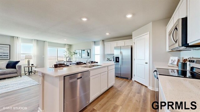 8512 S 179th St, Omaha, NE 68137 - kitchen with appliances with stainless steel finishes, a sink, white cabinetry, open floor plan, and light wood finished floors