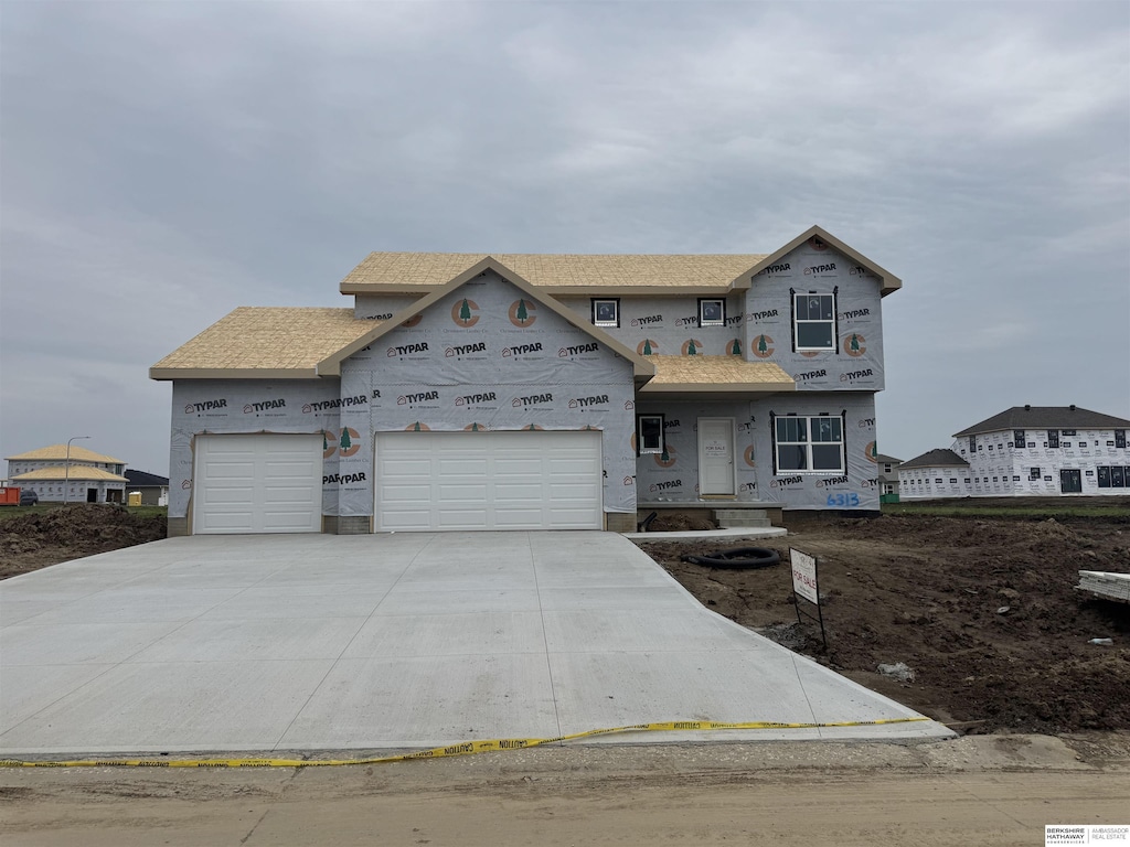 6313 N 209th St, Elkhorn, NE 68022 - unfinished property featuring a garage, concrete driveway, and stucco siding
