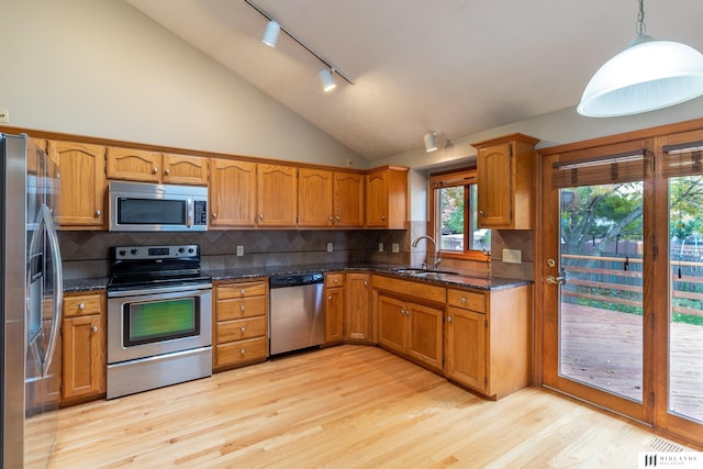 7824 La Vista Dr, La Vista, NE 68128 - kitchen with stainless steel appliances, track lighting, brown cabinetry, and lofted ceiling