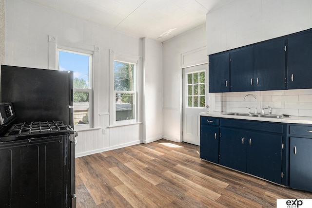 4701 Davenport St, Omaha, NE 68132 - kitchen with blue cabinets, black range with gas cooktop, dark wood-type flooring, decorative backsplash, and light countertops