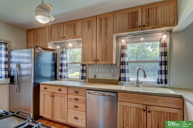 902 S 57th St, Omaha, NE 68106 - kitchen with stainless steel appliances, light brown cabinetry, light countertops, and healthy amount of natural light