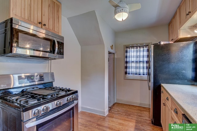 902 S 57th St, Omaha, NE 68106 - kitchen with stainless steel appliances, light wood-style floors, light brown cabinets, a ceiling fan, and light stone countertops