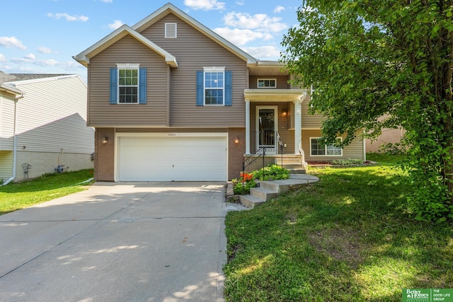 14463 Reynolds St, Omaha, NE 68007 - split foyer home featuring concrete driveway, a front yard, an attached garage, and brick siding