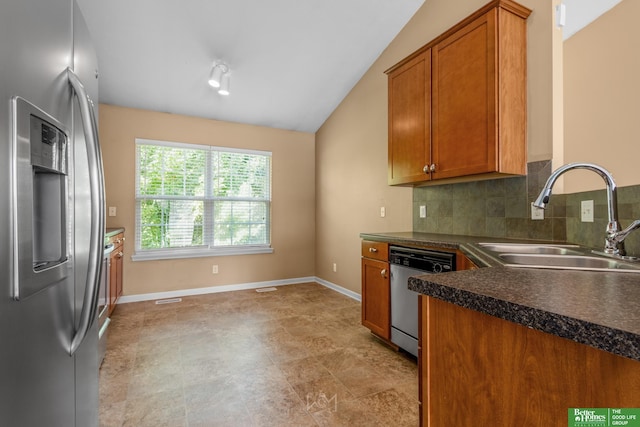 14463 Reynolds St, Omaha, NE 68007 - kitchen featuring appliances with stainless steel finishes, dark countertops, brown cabinets, tasteful backsplash, and vaulted ceiling
