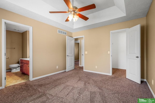 14463 Reynolds St, Omaha, NE 68007 - unfurnished bedroom featuring a raised ceiling, light carpet, ensuite bathroom, and ceiling fan