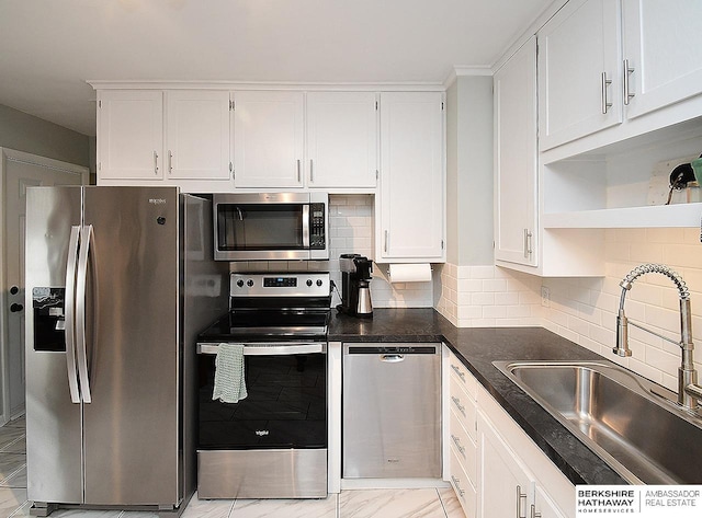 6144 Seward St, Omaha, NE 68104 - kitchen with appliances with stainless steel finishes, a sink, white cabinets, and dark countertops
