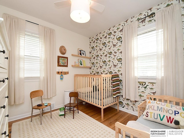6144 Seward St, Omaha, NE 68104 - bedroom featuring wood finished floors, wallpapered walls, and baseboards