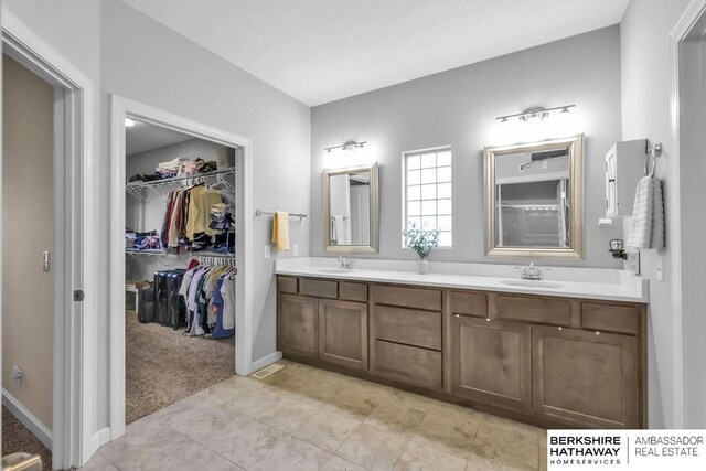 14807 S 24th St, Bellevue, NE 68123 - full bath with double vanity, a walk in closet, and baseboards