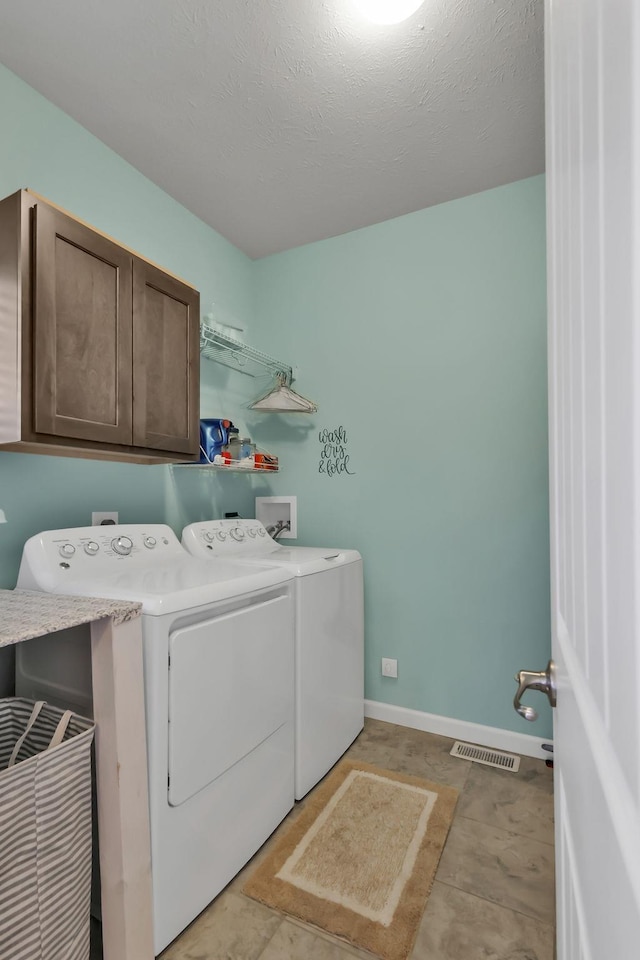 14807 S 24th St, Bellevue, NE 68123 - washroom with washing machine and dryer, cabinet space, baseboards, and a textured ceiling