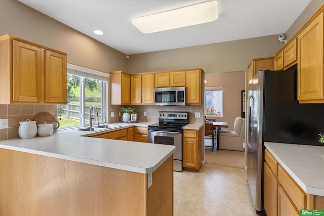 4602 N 155th Ave, Omaha, NE 68116 - kitchen featuring appliances with stainless steel finishes, a sink, light countertops, a peninsula, and decorative backsplash