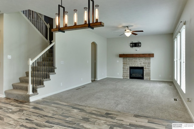 18337 Polk St, Omaha, NE 68135 - unfurnished living room featuring wood finished floors, a ceiling fan, arched walkways, stairs, and baseboards