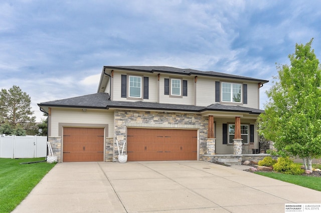 18337 Polk St, Omaha, NE 68135 - view of front of house with covered porch, driveway, an attached garage, and stone siding
