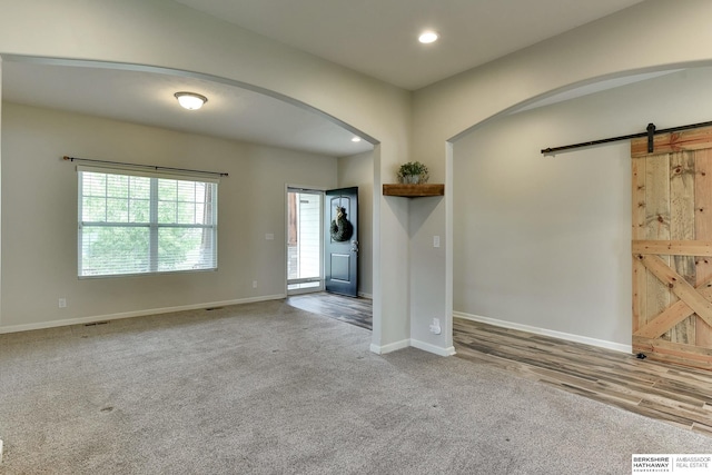 18337 Polk St, Omaha, NE 68135 - entryway featuring a barn door, arched walkways, carpet floors, baseboards, and recessed lighting