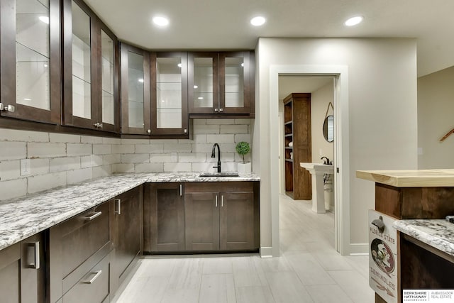 18337 Polk St, Omaha, NE 68135 - kitchen with dark brown cabinetry, a sink, backsplash, and recessed lighting