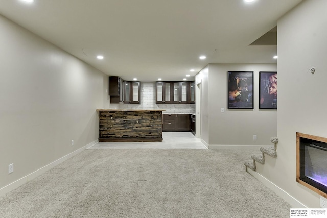18337 Polk St, Omaha, NE 68135 - unfurnished living room with light carpet, recessed lighting, baseboards, a glass covered fireplace, and stairway