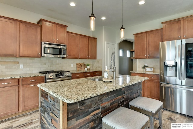 18337 Polk St, Omaha, NE 68135 - kitchen featuring stainless steel appliances, arched walkways, a sink, brown cabinets, and backsplash