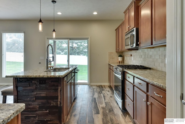 18337 Polk St, Omaha, NE 68135 - kitchen with stainless steel appliances, a sink, wood finished floors, brown cabinetry, and decorative backsplash