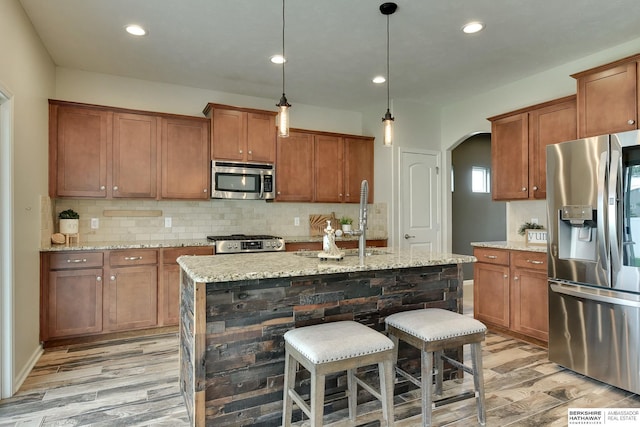 18337 Polk St, Omaha, NE 68135 - kitchen with stainless steel appliances, a sink, light wood finished floors, brown cabinets, and recessed lighting