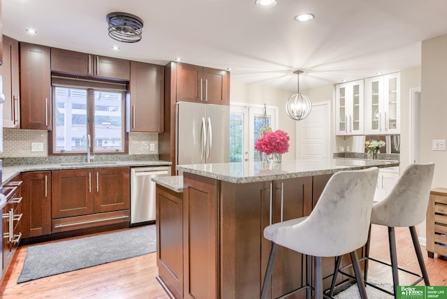 1008 J E George Blvd, Omaha, NE 68132 - kitchen with stainless steel appliances, a sink, a kitchen island, a kitchen bar, and backsplash