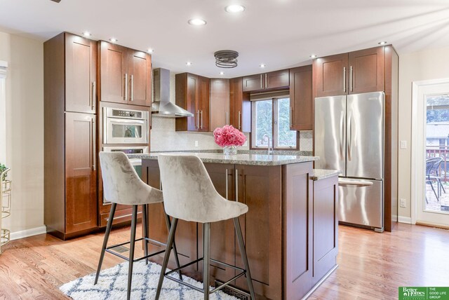 1008 J E George Blvd, Omaha, NE 68132 - kitchen featuring freestanding refrigerator, wall chimney exhaust hood, baseboards, a kitchen island, and recessed lighting