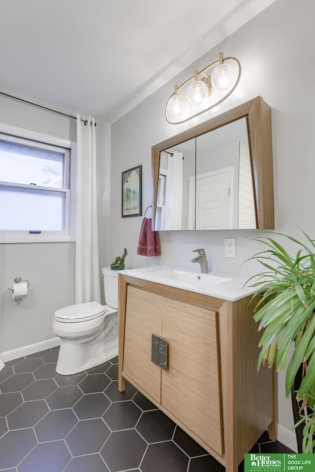 1008 J E George Blvd, Omaha, NE 68132 - bathroom featuring toilet, vanity, and baseboards