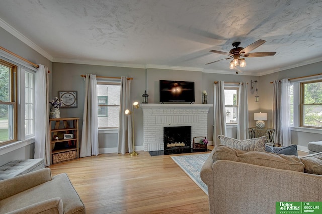 406 S 49th St, Omaha, NE 68132 - living area with light wood-style floors, a brick fireplace, a ceiling fan, baseboards, and ornamental molding