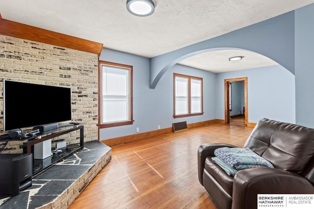 929 Main St, Seward, NE 68434 - living room with arched walkways, hardwood / wood-style floors, baseboards, and a textured ceiling