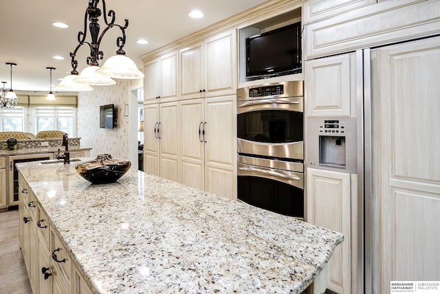 12829 Izard St, Omaha, NE 68154 - kitchen featuring stainless steel double oven, a kitchen island, a sink, light stone countertops, and paneled built in fridge