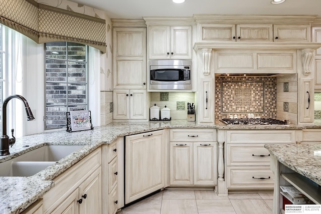 12829 Izard St, Omaha, NE 68154 - kitchen featuring a sink, stainless steel appliances, tasteful backsplash, light stone counters, and recessed lighting