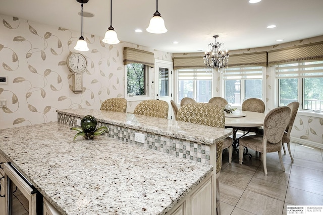 12829 Izard St, Omaha, NE 68154 - kitchen with wine cooler, wallpapered walls, a kitchen island, decorative light fixtures, and light stone countertops