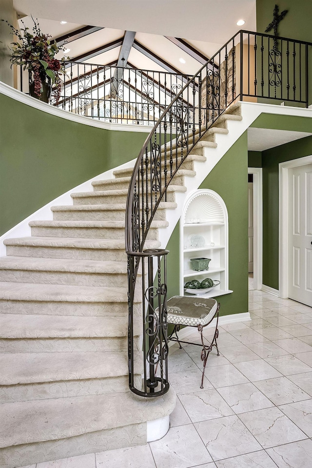 12829 Izard St, Omaha, NE 68154 - stairs featuring built in shelves, baseboards, high vaulted ceiling, marble finish floors, and recessed lighting