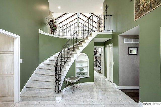 12829 Izard St, Omaha, NE 68154 - stairway featuring a towering ceiling, baseboards, and marble look tile flooring