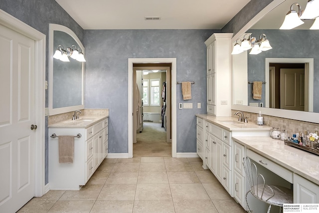 12829 Izard St, Omaha, NE 68154 - full bath with two vanities, tile patterned flooring, baseboards, and tasteful backsplash