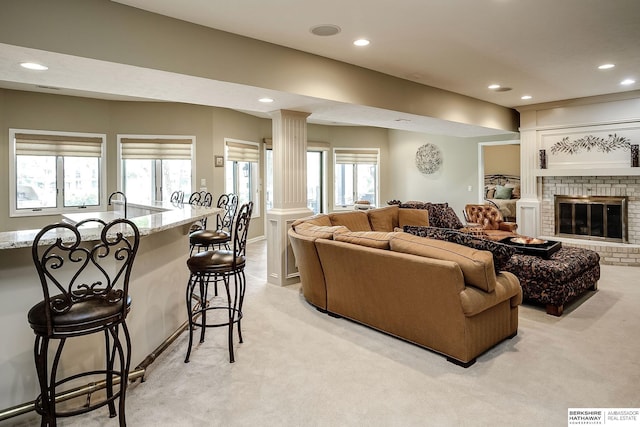 12829 Izard St, Omaha, NE 68154 - living area with light carpet, recessed lighting, ornate columns, plenty of natural light, and a brick fireplace