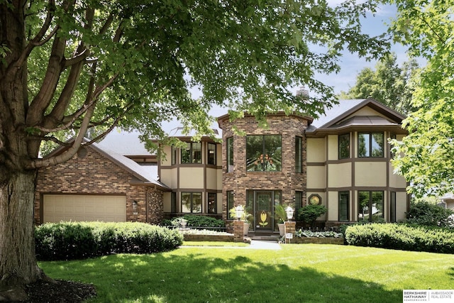 12829 Izard St, Omaha, NE 68154 - tudor-style house with brick siding, a front yard, an attached garage, and stucco siding