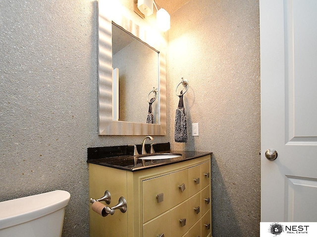 7615 Greycliff Dr, Lincoln, NE 68516 - half bath with vanity, toilet, and a textured wall