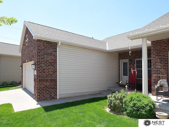 7615 Greycliff Dr, Lincoln, NE 68516 - view of side of property featuring brick siding, concrete driveway, and roof with shingles