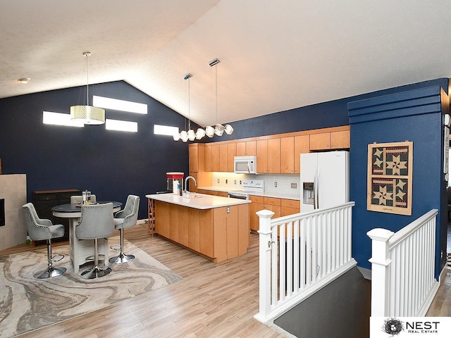 7615 Greycliff Dr, Lincoln, NE 68516 - kitchen with white appliances, light countertops, light wood-type flooring, a sink, and hanging light fixtures