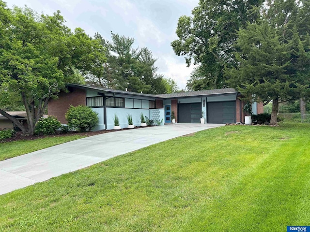 5941 Margo Dr, Lincoln, NE 68510 - view of front of property with a front yard, an attached garage, brick siding, and concrete driveway