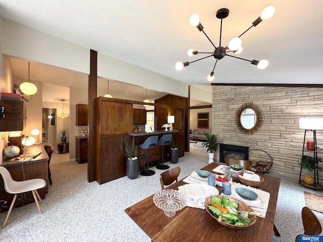 5941 Margo Dr, Lincoln, NE 68510 - living room featuring a stone fireplace, a chandelier, and lofted ceiling