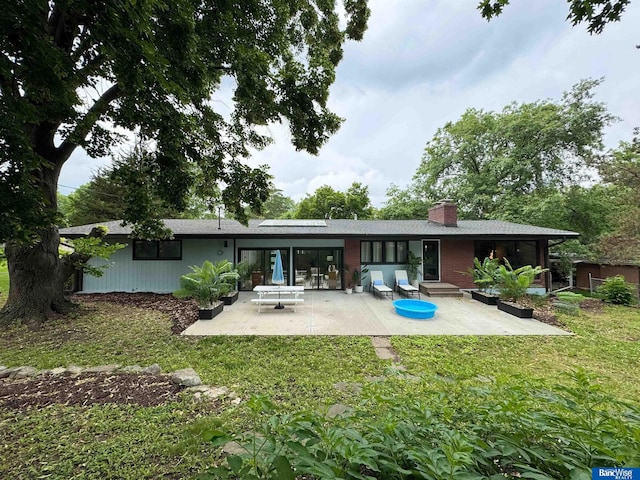5941 Margo Dr, Lincoln, NE 68510 - rear view of house with a patio, a yard, and a chimney