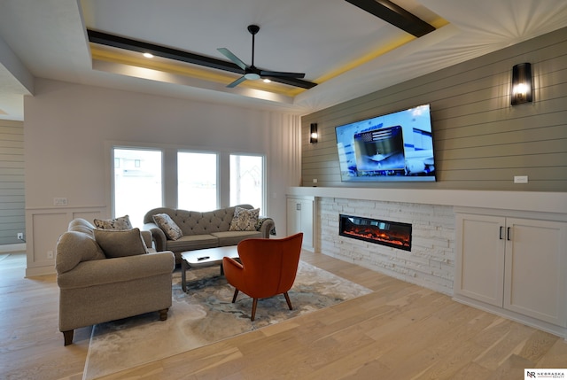 11602 S 116th St, Papillion, NE 68046 - living area featuring ceiling fan, a fireplace, light wood-type flooring, a raised ceiling, and wood walls
