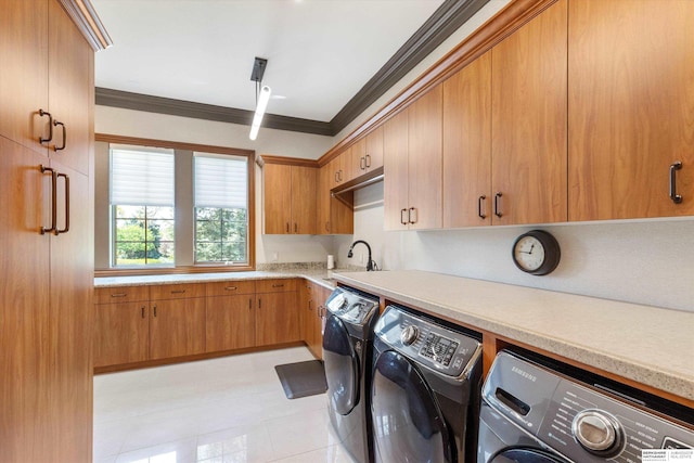 1215 N 136th St, Omaha, NE 68154 - laundry room featuring washing machine and clothes dryer, crown molding, cabinet space, and light tile patterned floors