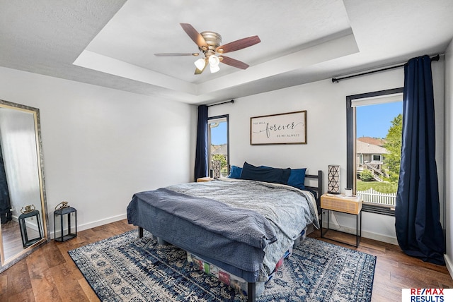 21808 Hilltop Ave, Gretna, NE 68028 - bedroom featuring a tray ceiling, wood-type flooring, and a ceiling fan