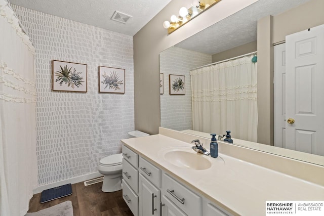 16325 Erskine St, Omaha, NE 68116 - bathroom with wood finished floors, vanity, toilet, and a textured ceiling