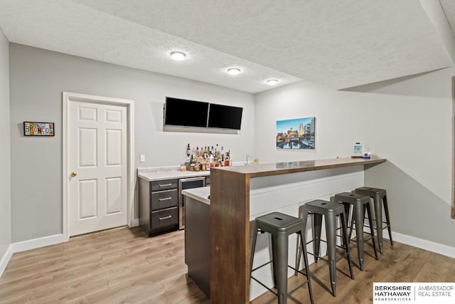 16325 Erskine St, Omaha, NE 68116 - indoor bar featuring light wood-style floors, baseboards, a textured ceiling, and wine cooler