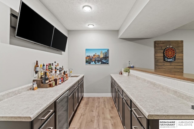 16325 Erskine St, Omaha, NE 68116 - indoor dry bar featuring a textured ceiling, light wood finished floors, baseboards, and beverage cooler